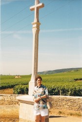 Karen Cares in front of the famous stone cross associated with Romanee Conti vineyard, Cote de Nuits
